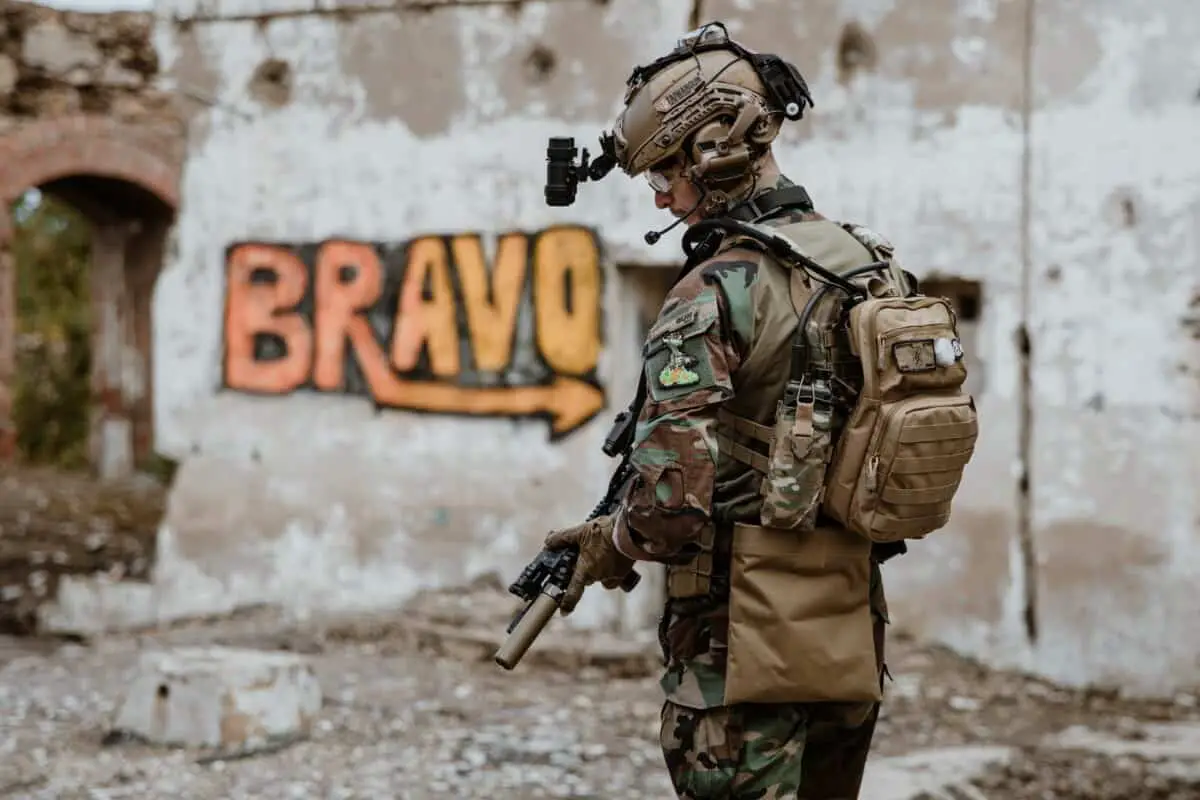 An airsoft player next to a bravo paining